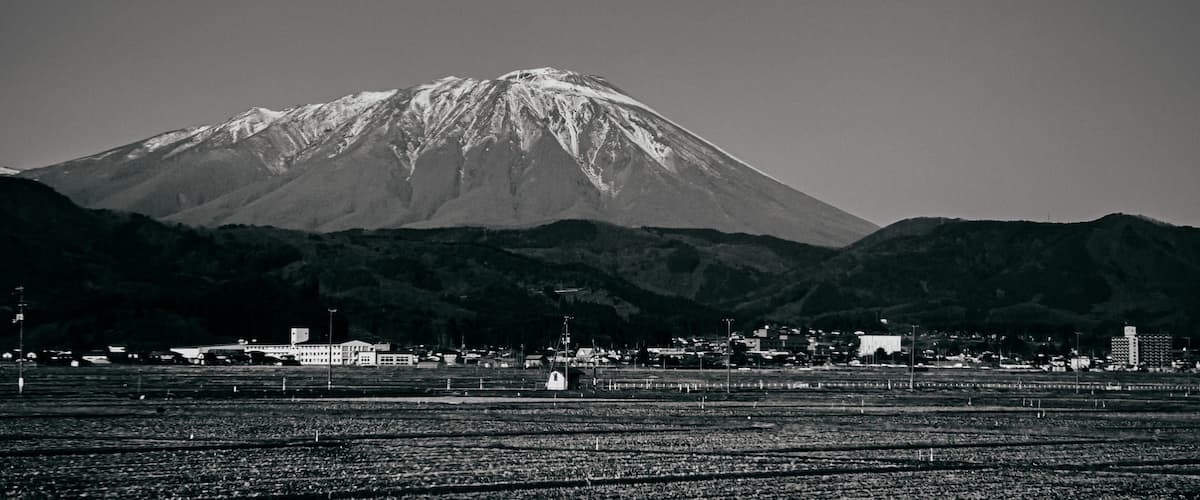 A snow-capped mountain with a town in the foreground.