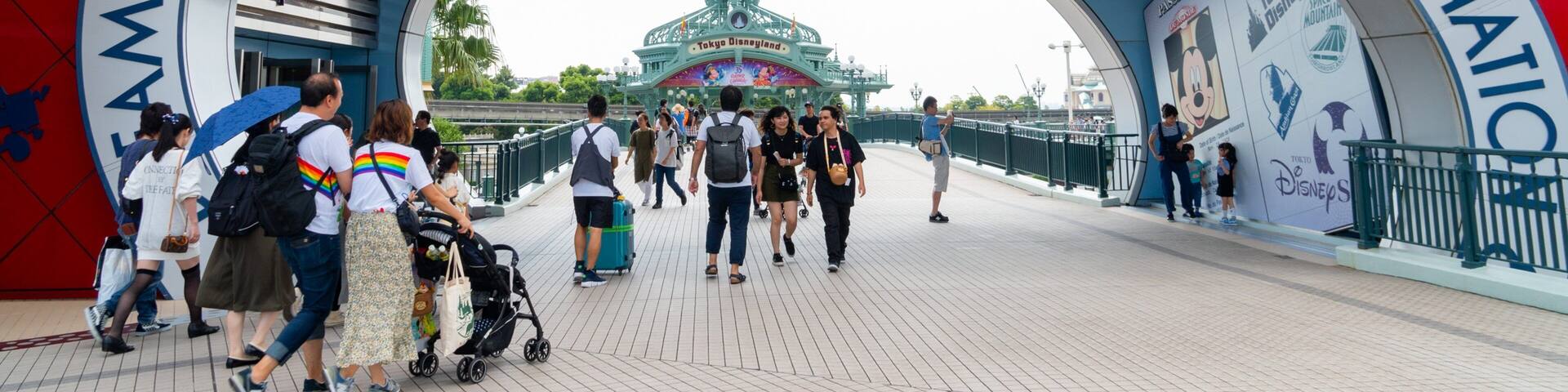 The entrance to Tokyo Disney Resort with a large archway and a view of the park's entrance building.