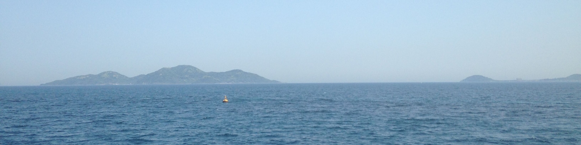 筑前大島行きの「フェリーおおしま」より望む地島(左)と鐘ノ岬(右)