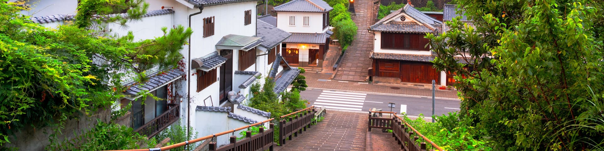 A traditional Japanese village with a steep stone staircase leading to a temple.