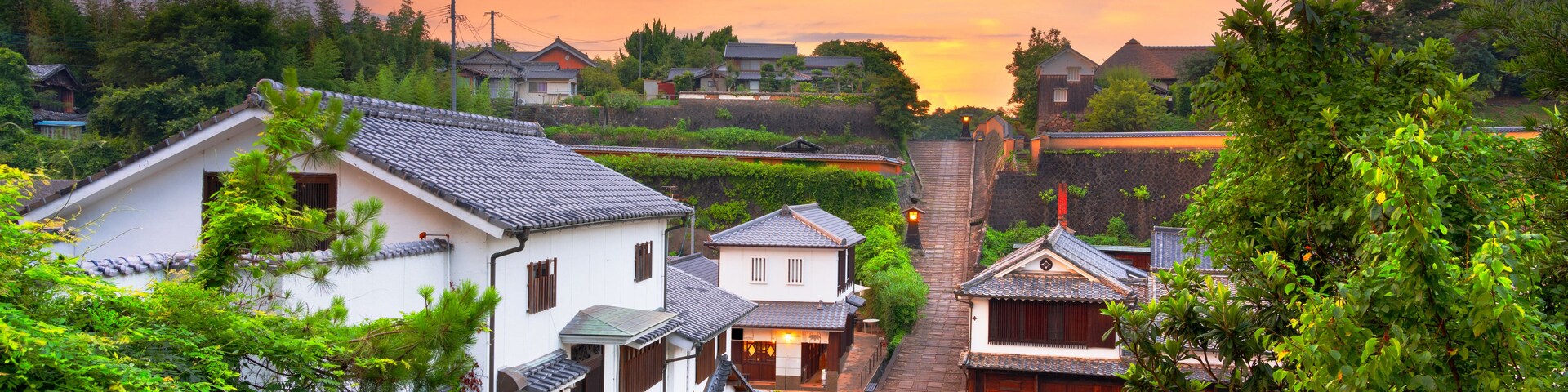 Uma vila japonesa tradicional com uma escadaria de pedra íngreme que leva a um templo.