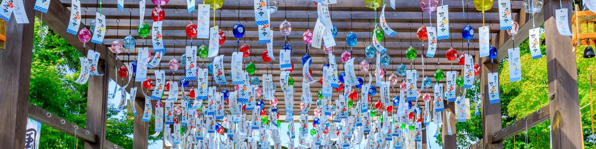 A traditional Japanese torii gate with colorful paper lanterns hanging above.