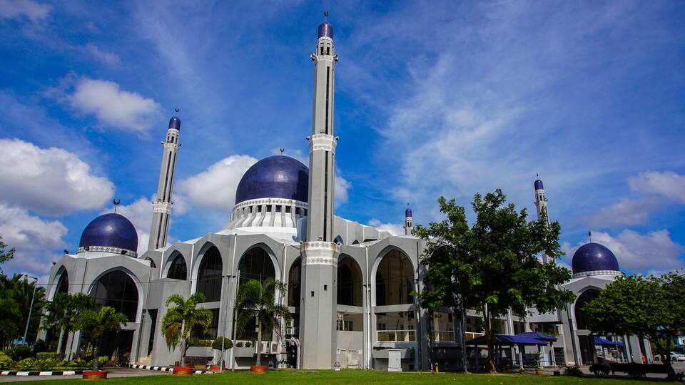A mosque with two large domes and a tall minaret.