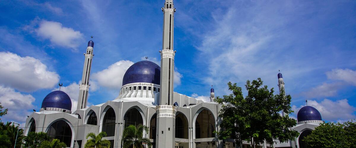 A mosque with two large domes and a tall minaret.