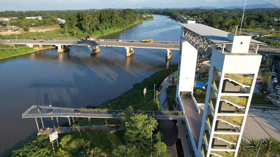 A river with a bridge, a modern building, and a road.