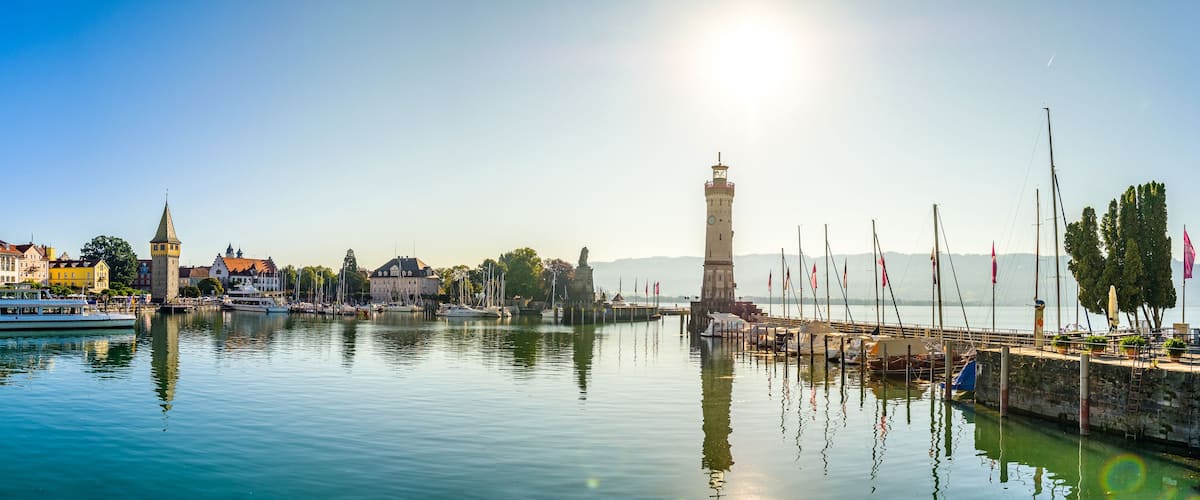 Ein Hafen mit Booten, einem Turm und Gebäuden entlang der Uferlinie.