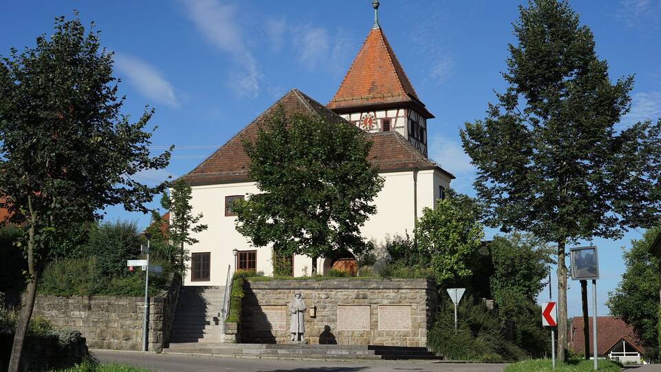 A church with a red-tiled roof and a bell tower.