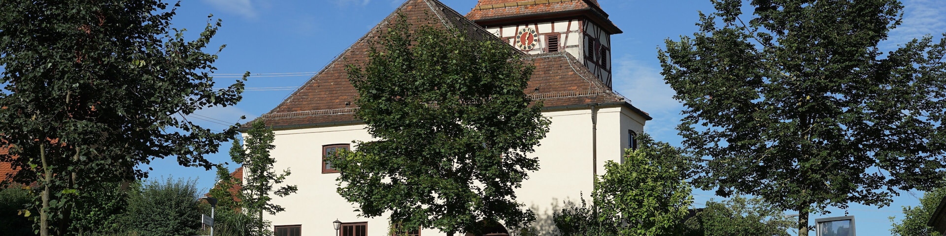 Schwäbisch Hall, Stadtteil Gailenkirchen: Blick von Westen auf die Pfarrkirche, davor das Gefallenendenkmal. Standort: auf der Waldenburger Straße.