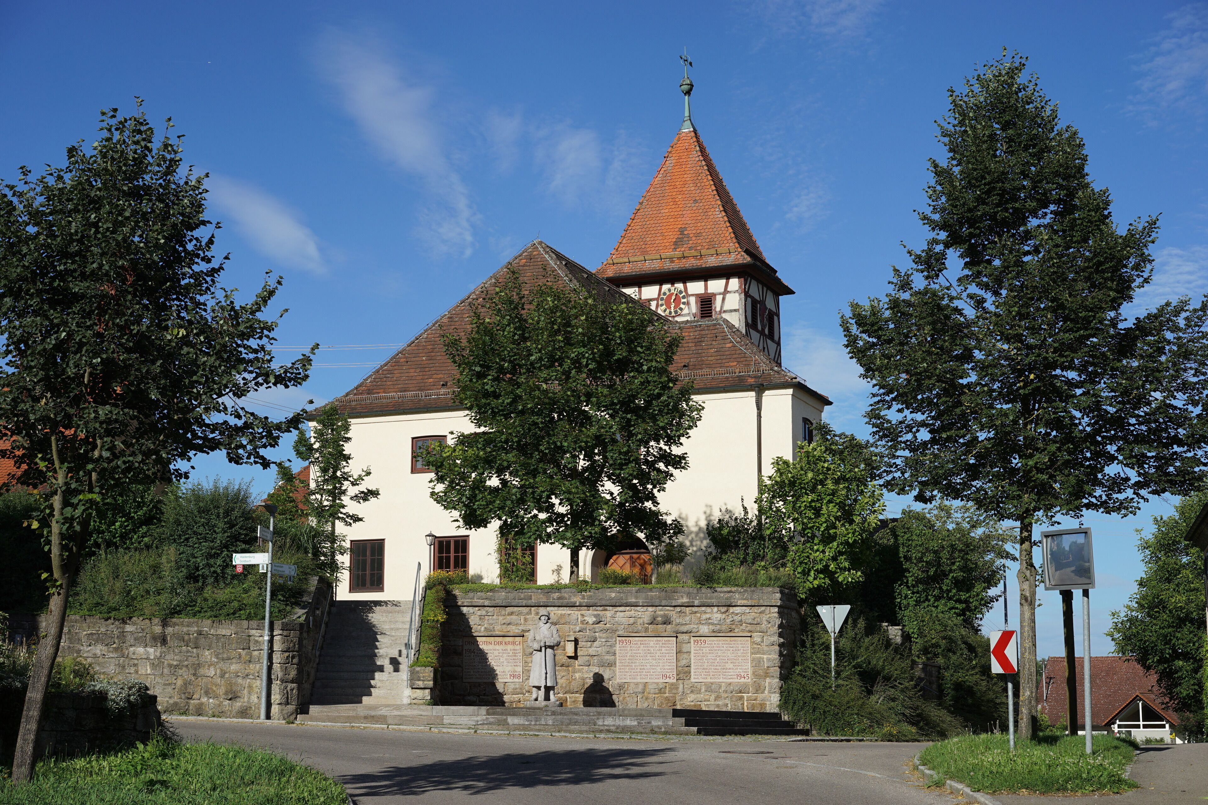 A church with a red-tiled roof and a bell tower.