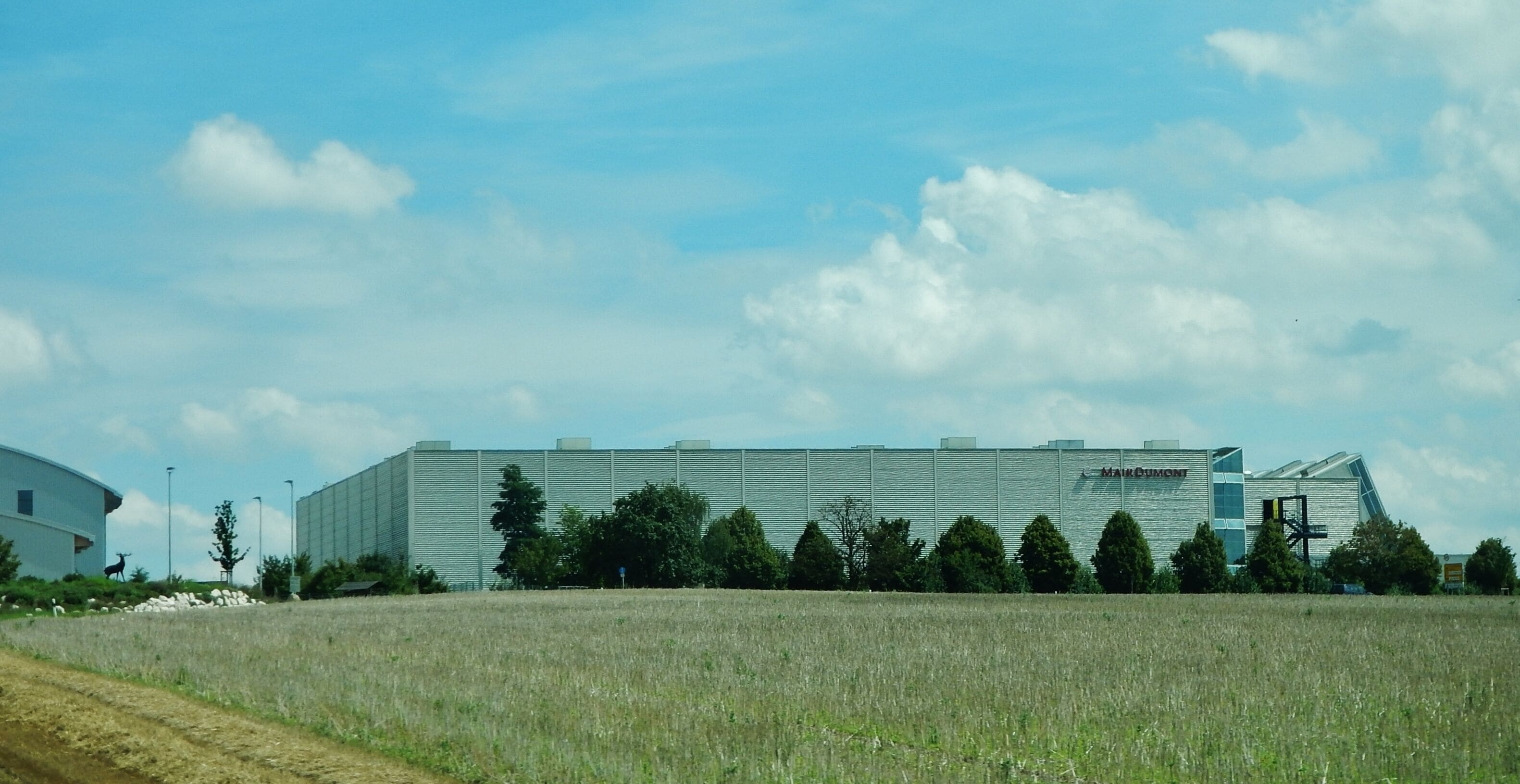 A large industrial building with a flat roof and a sign that reads "MAMMUT".