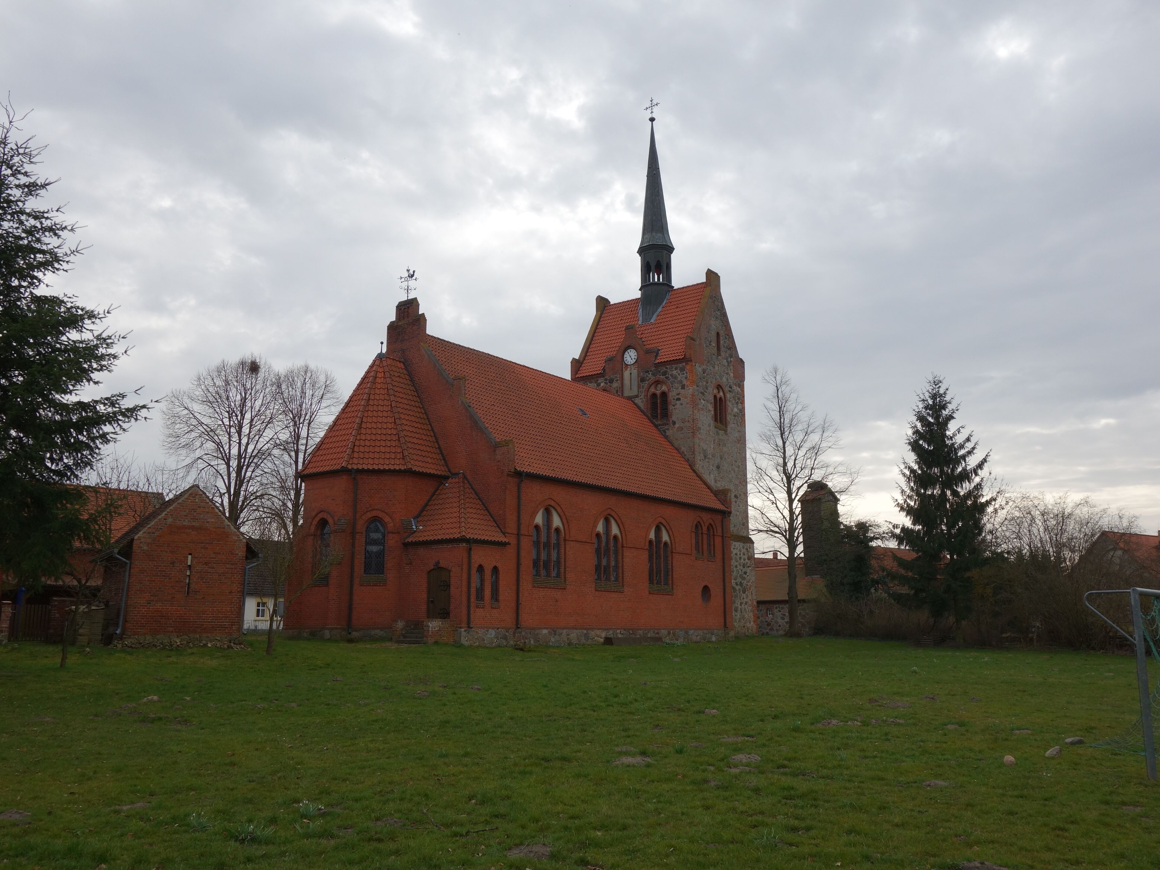 A church with a red roof and a tall steeple.