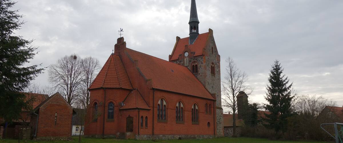 A church with a red roof and a tall steeple.