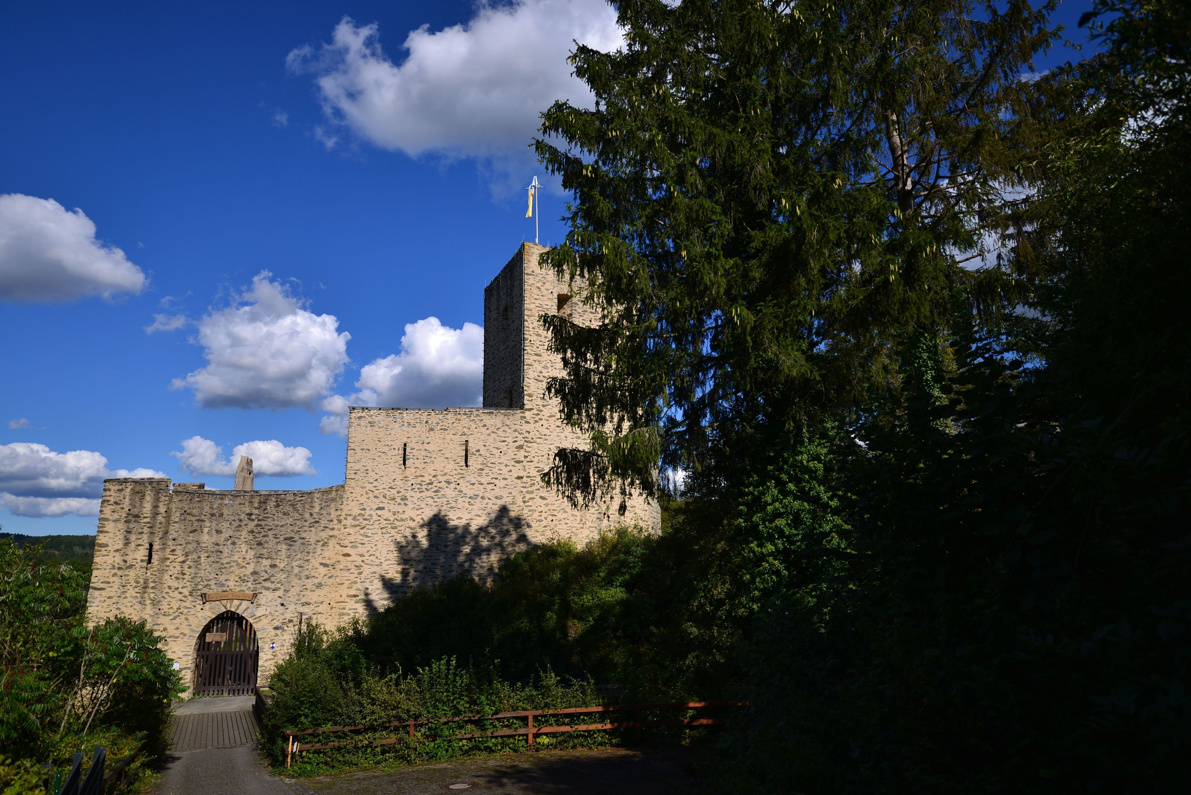 Old Freienfels Castle in Germany surrounded by green trees against the blue sky on a sunny day