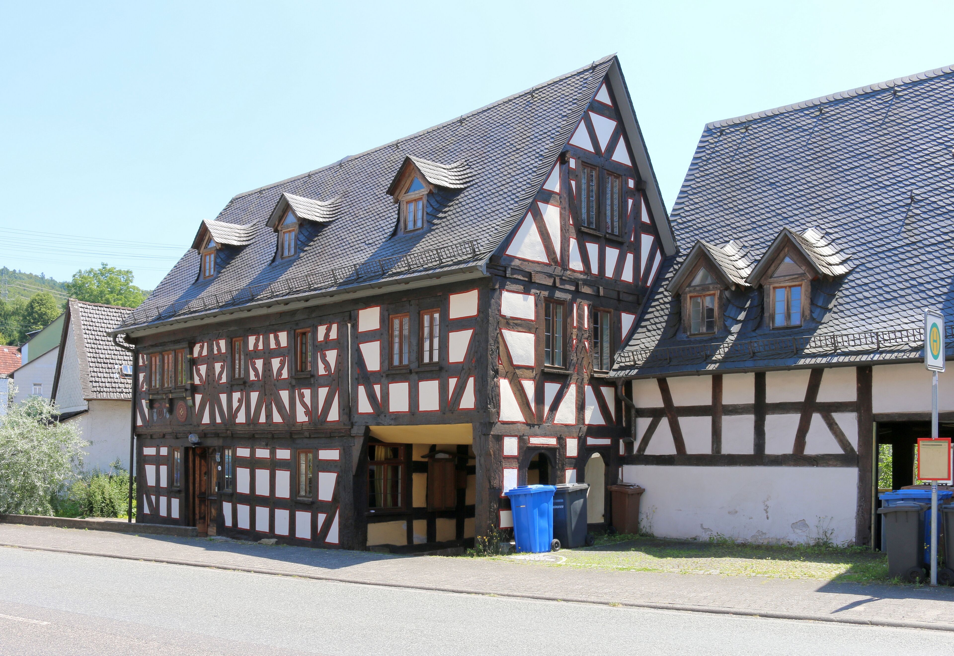 A traditional half-timbered house with a steeply pitched roof and dormer windows.