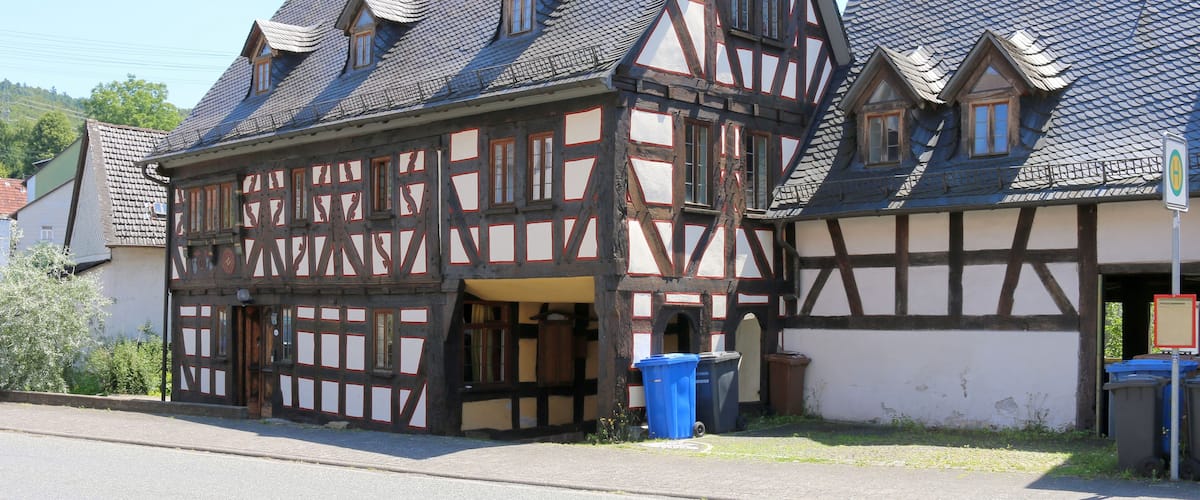 A traditional half-timbered house with a steeply pitched roof and dormer windows.