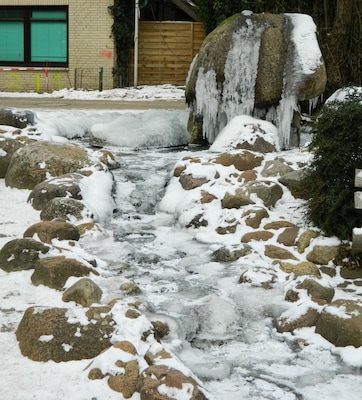 Un arroyo cubierto de nieve con rocas y estalactitas.