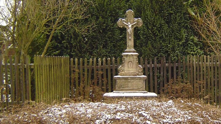 Wegkreuz bestehend aus Fundament, Sockel, Mittelteil und Kreuz. Material Sandstein.
