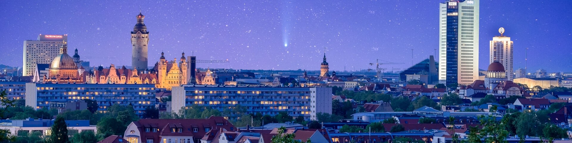 Un paisaje urbano al anochecer con edificios históricos y rascacielos modernos bajo un cielo estrellado.