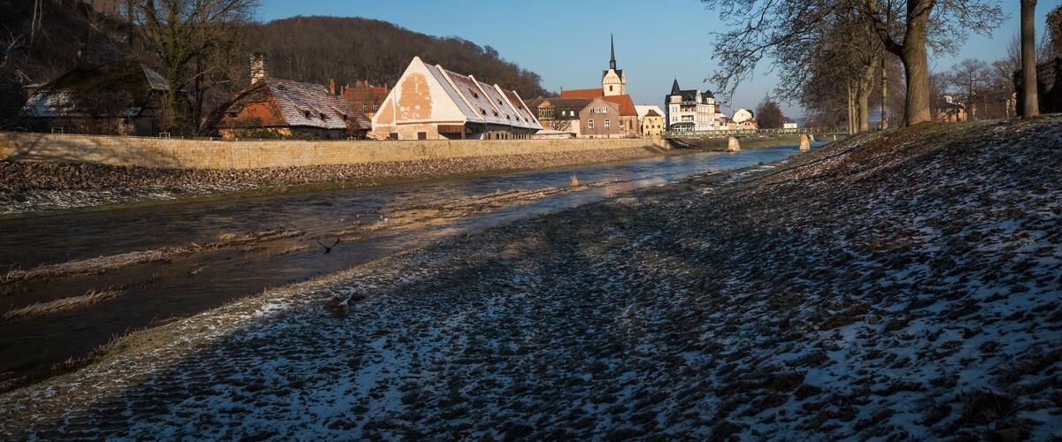 view of river and old town with church in winter