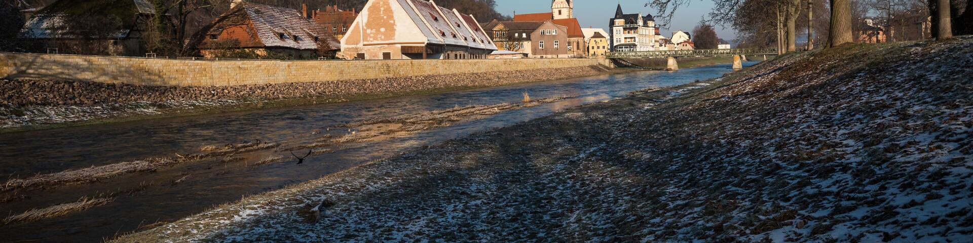 view of river and old town with church in winter