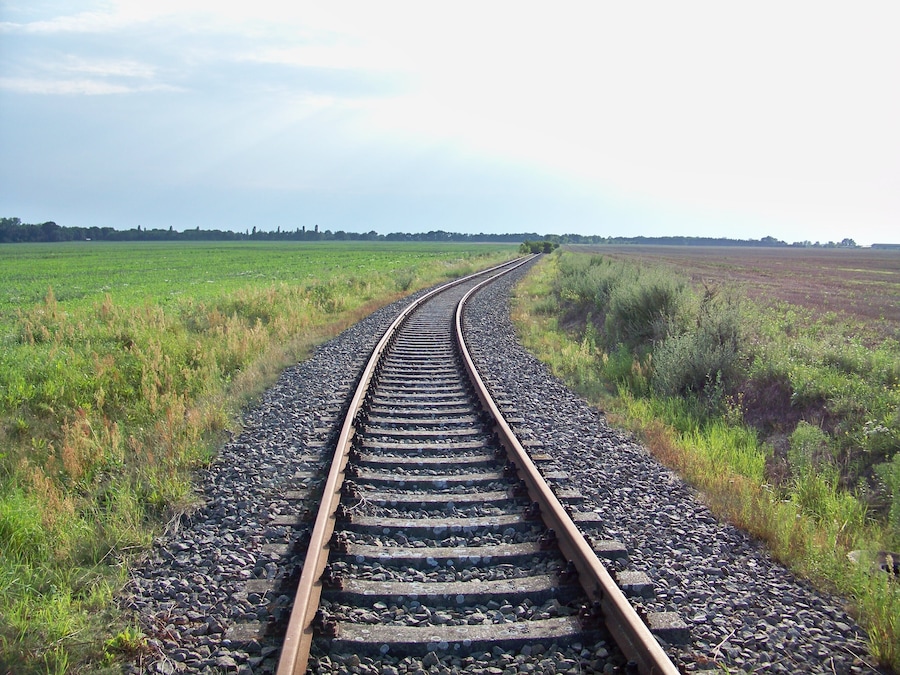 Eine sich durch ein Feld schlängelnde Eisenbahnlinie.