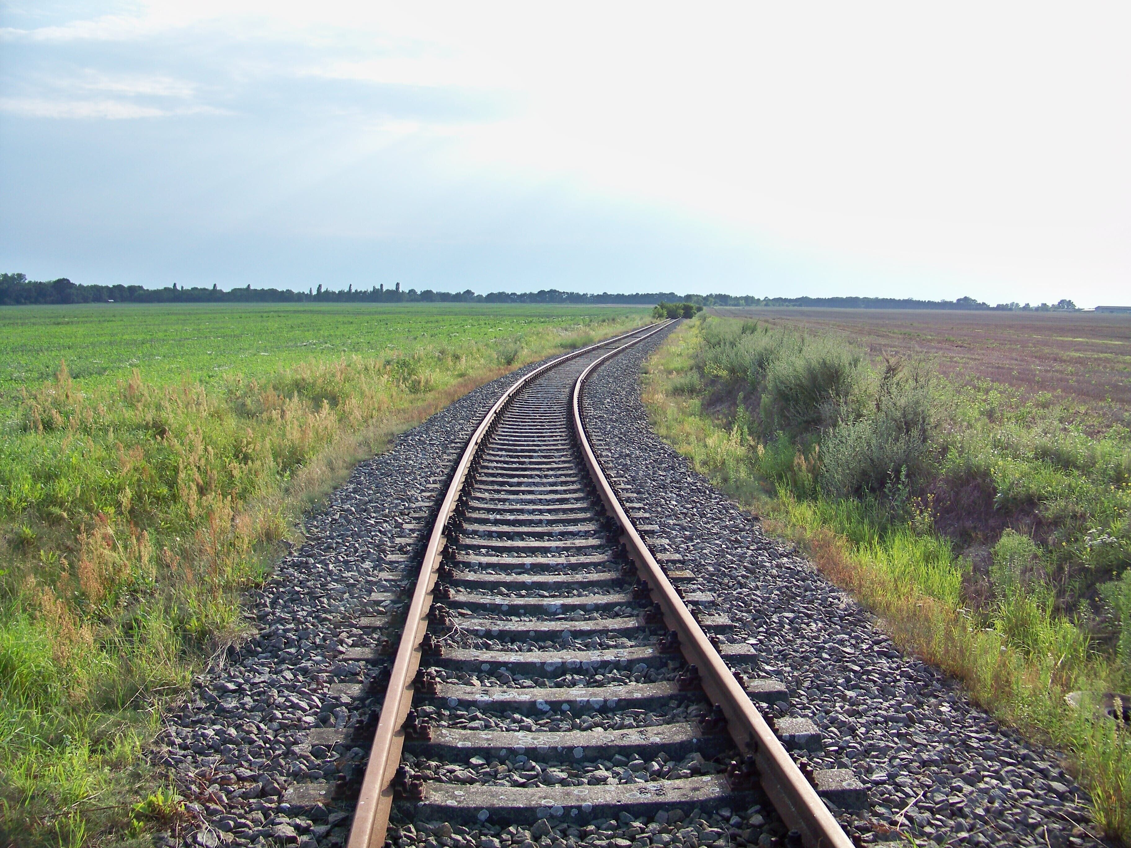 A railway track curving through a field.
