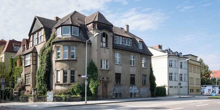 Un edificio histórico con torrecilla y muros cubiertos de hiedra.