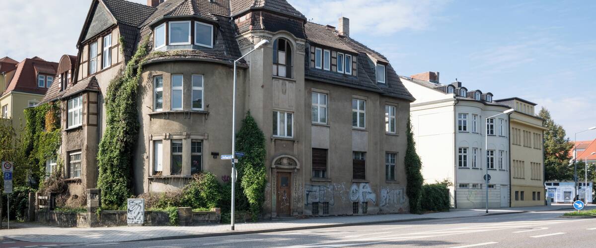 A historic building with a turret and ivy-covered walls.