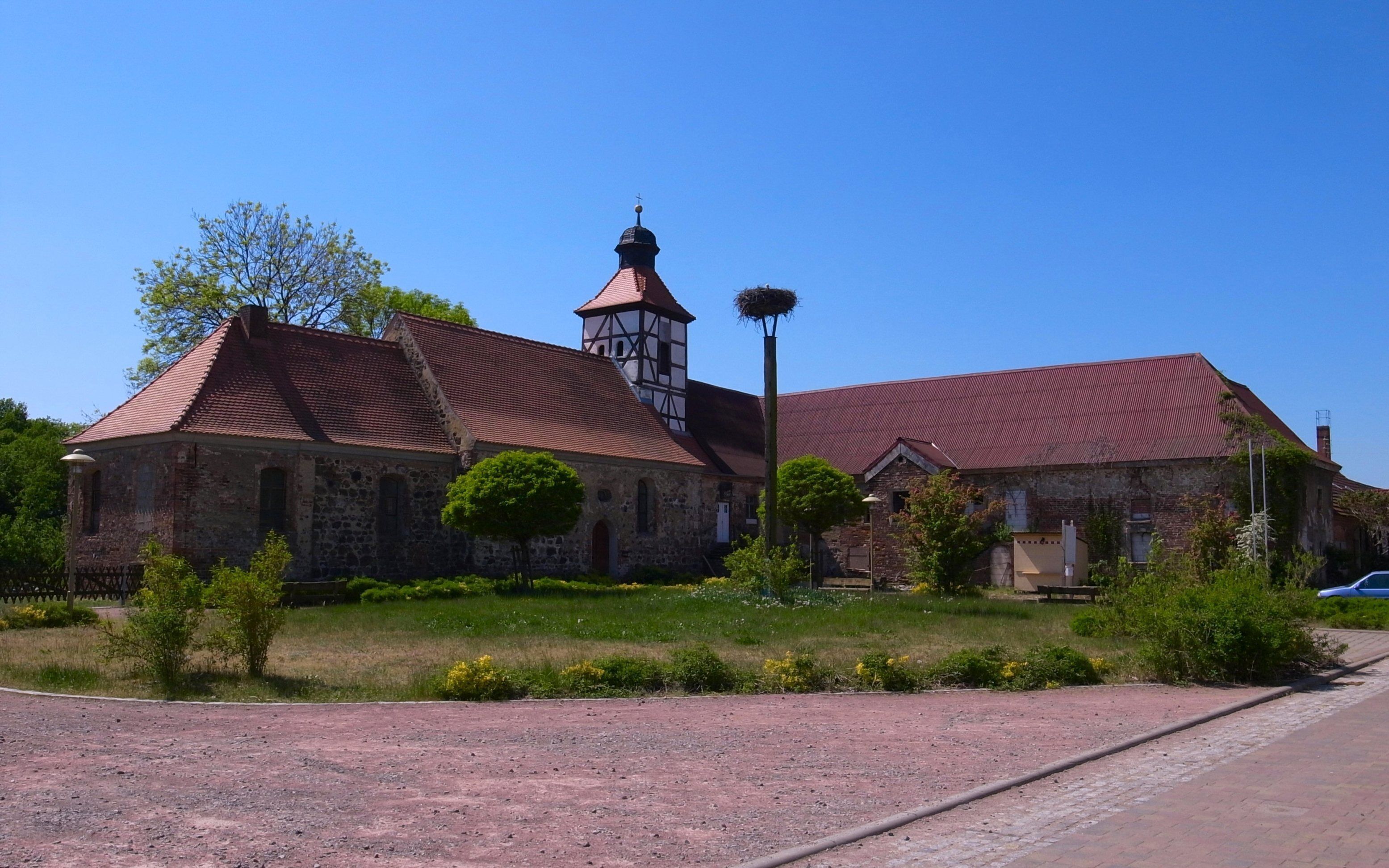 A church with a bell tower and a nest on top.
