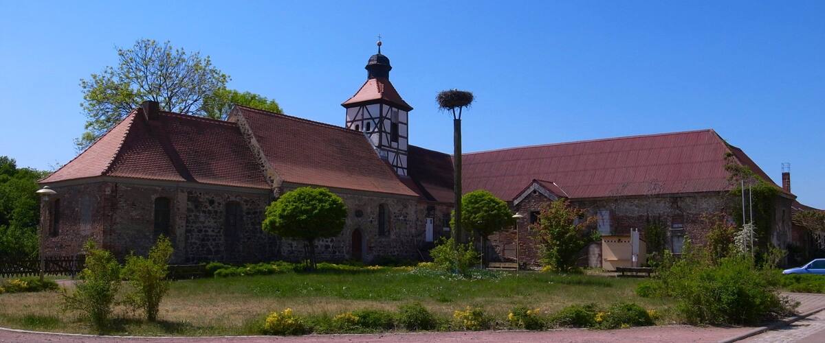 A church with a bell tower and a nest on top.
