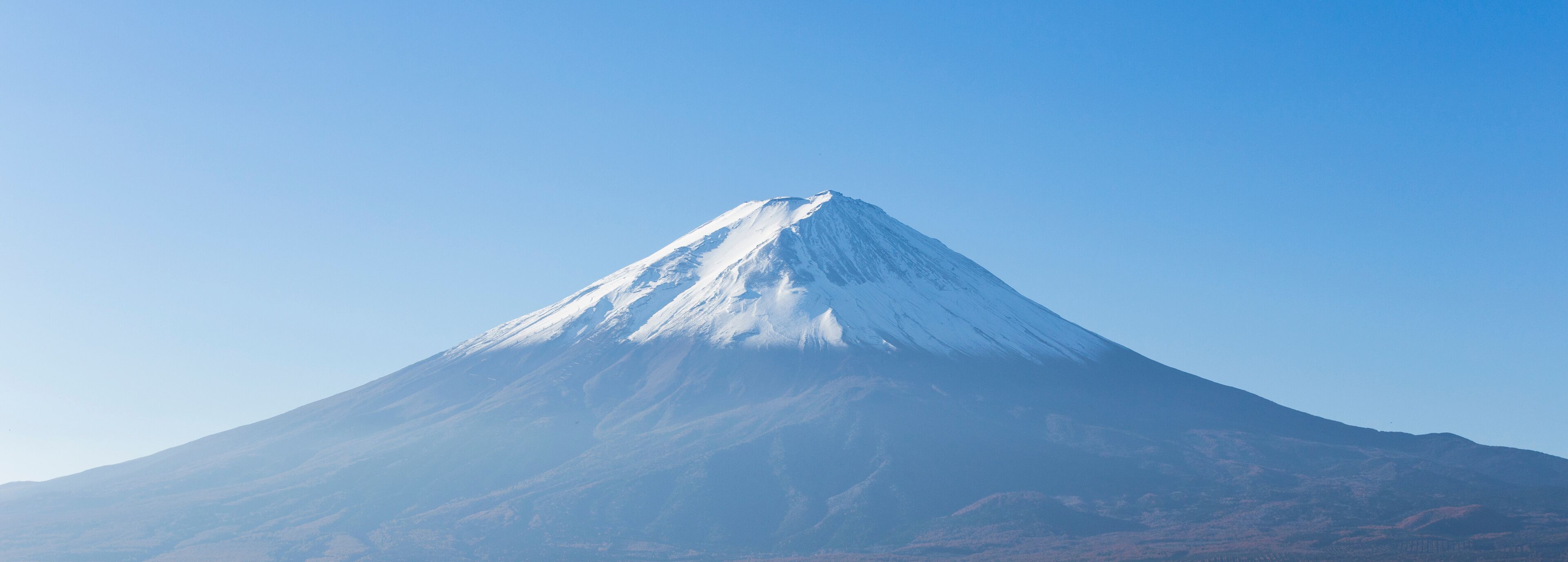 A snow-capped mountain under a clear blue sky.