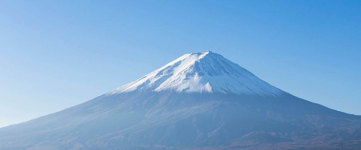 A snow-capped mountain under a clear blue sky.