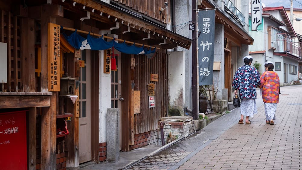 A traditional Japanese building with wooden elements and signage in Japanese.