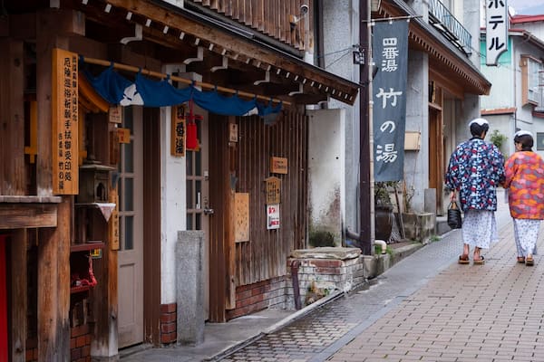 A traditional Japanese building with wooden elements and signage in Japanese.