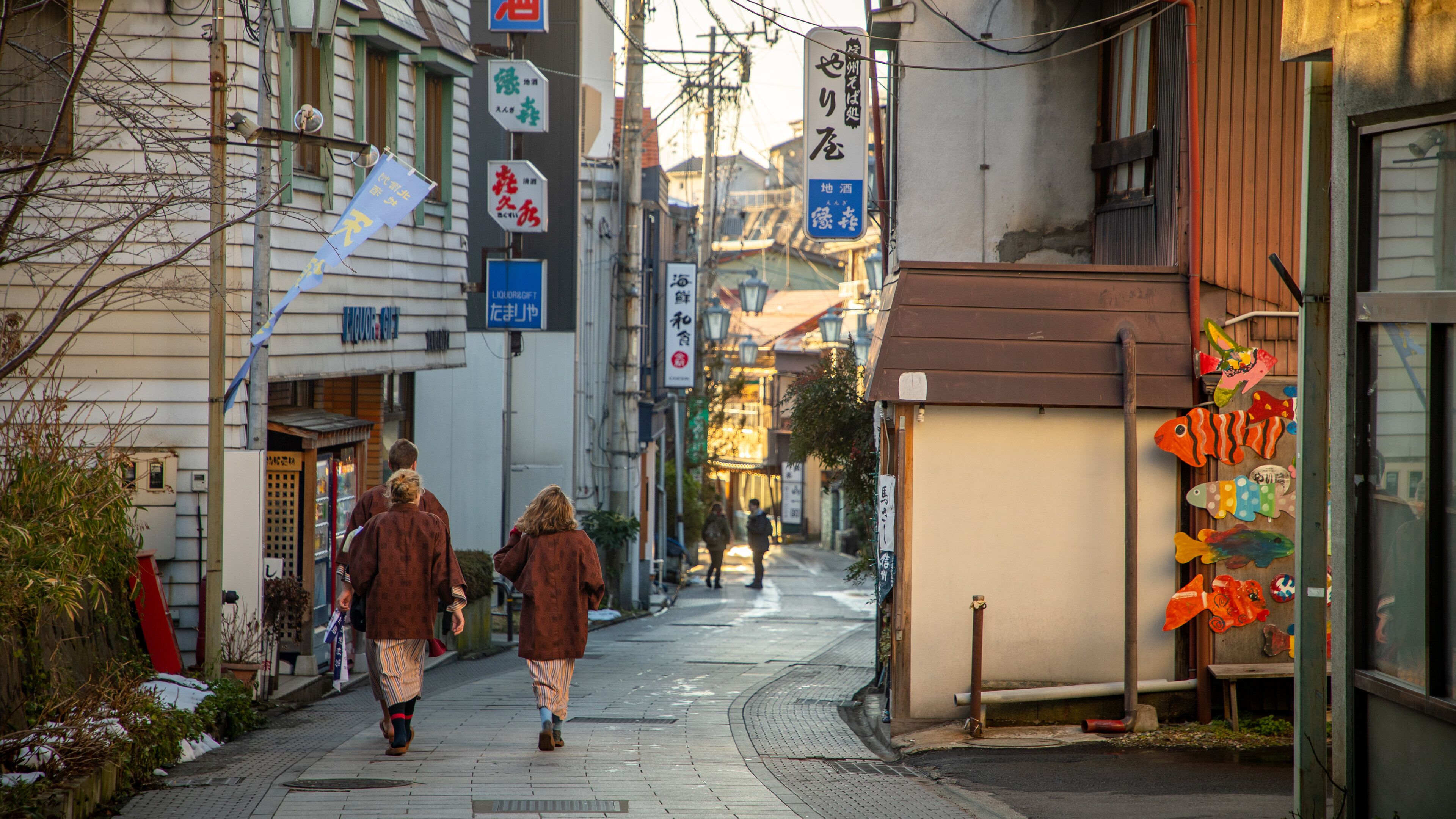 A narrow street lined with traditional buildings, some with signage in a foreign language.
