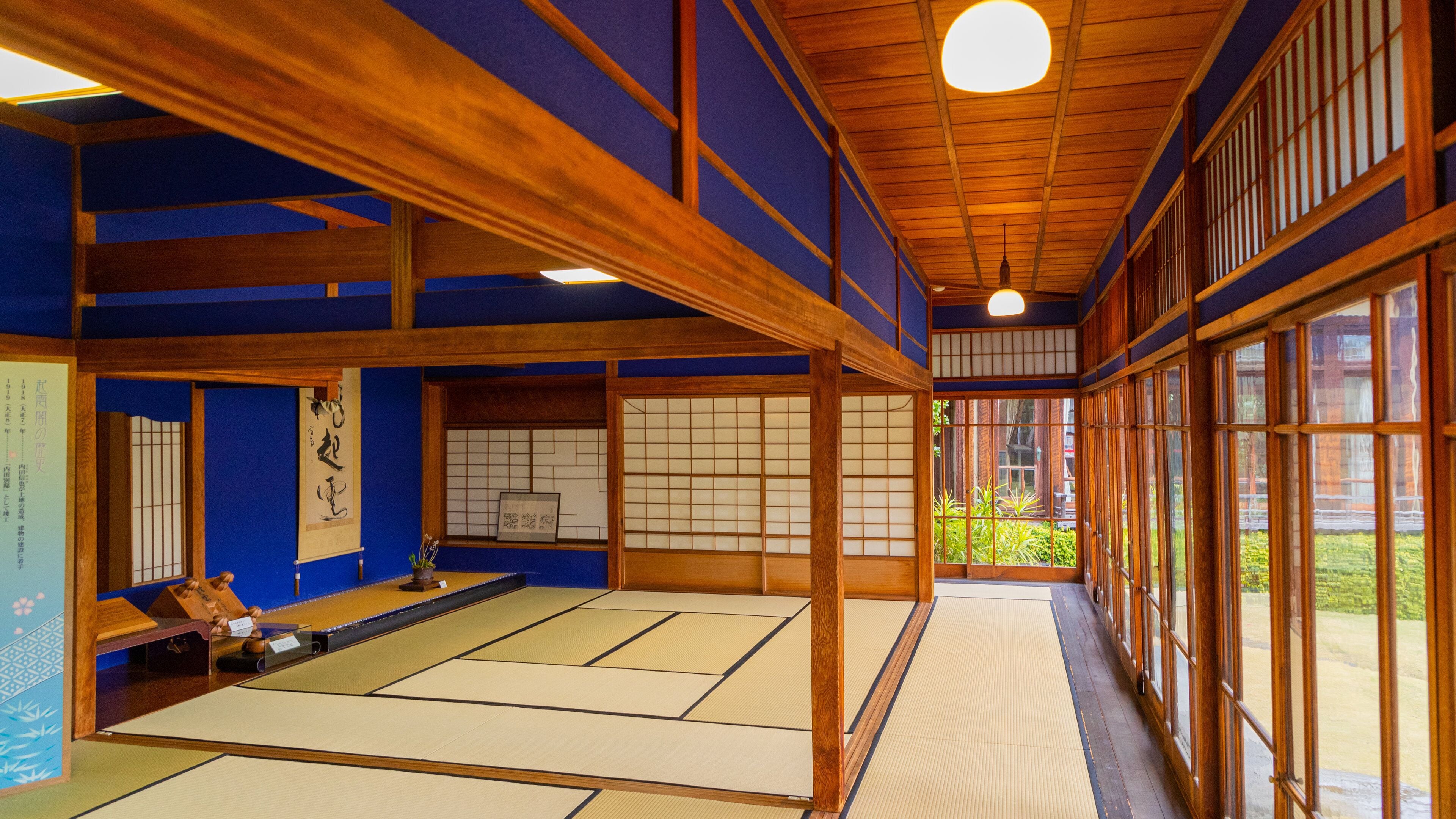 Una habitación japonesa tradicional con esteras de tatami, vigas de madera y paneles de papel shoji.