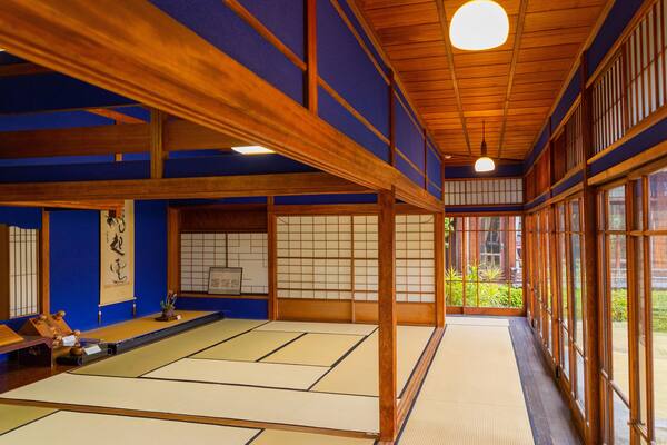 Um quarto japonês tradicional, com tatames, vigas de madeira e painéis shoji.