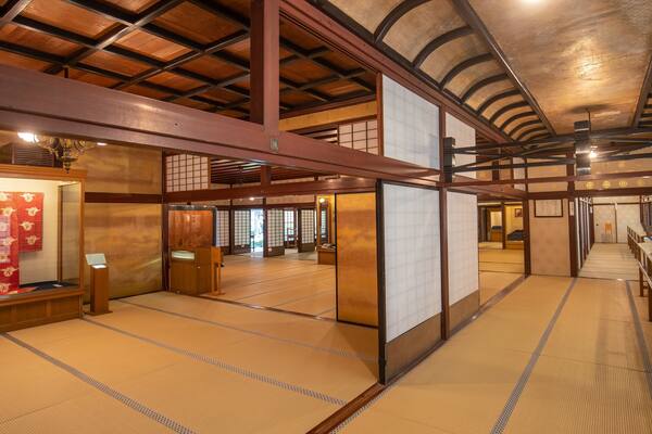 Une pièce de style japonais traditionnel, avec un sol recouvert de tatamis, des poutres en bois et des portes coulissantes.