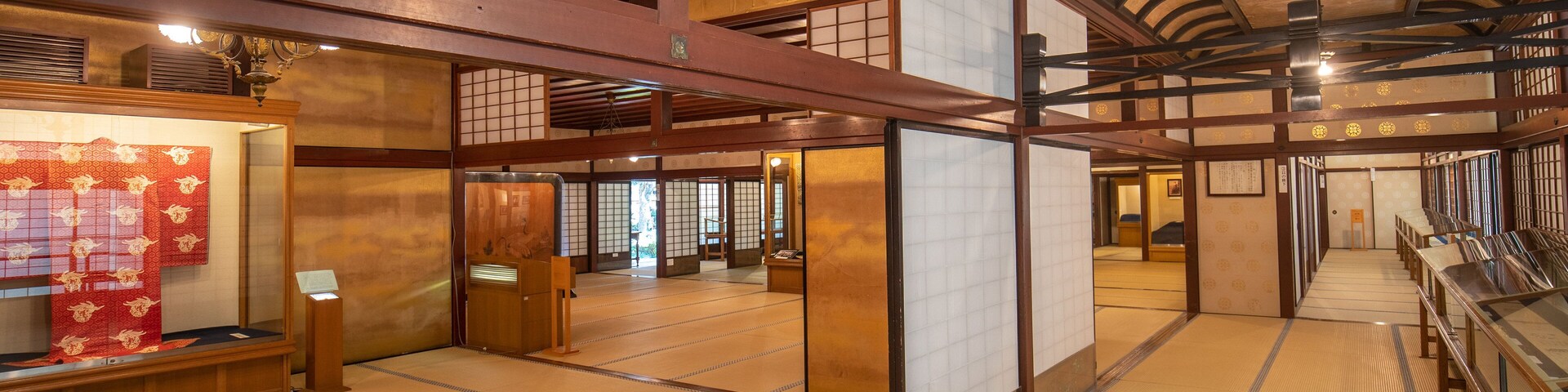 Um quarto japonês tradicional com piso de tatame, vigas de madeira e portas deslizantes.