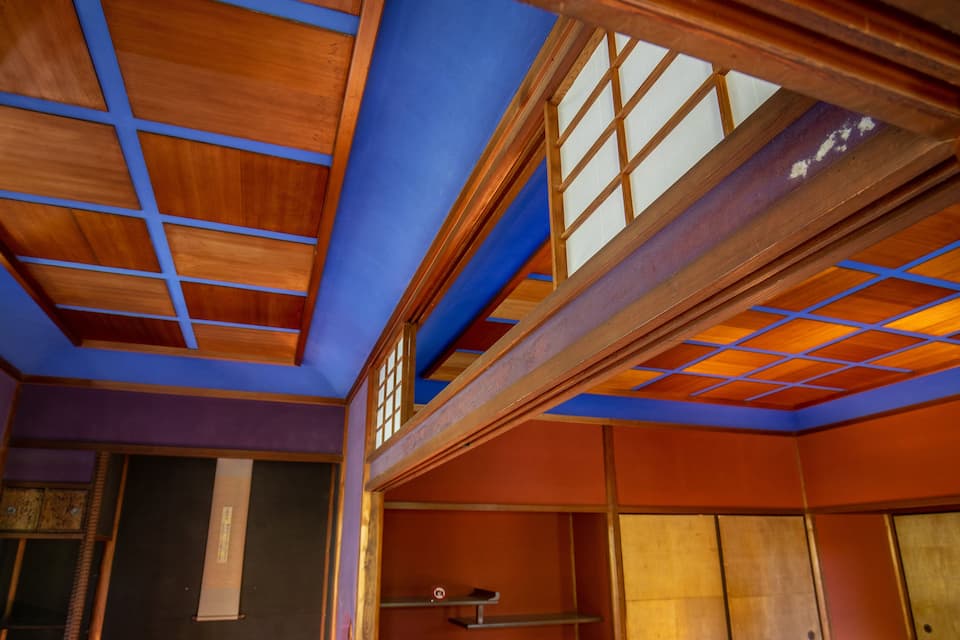 Een traditionele Japanse kamer met houten balken, tatami matten en schuifdeuren.