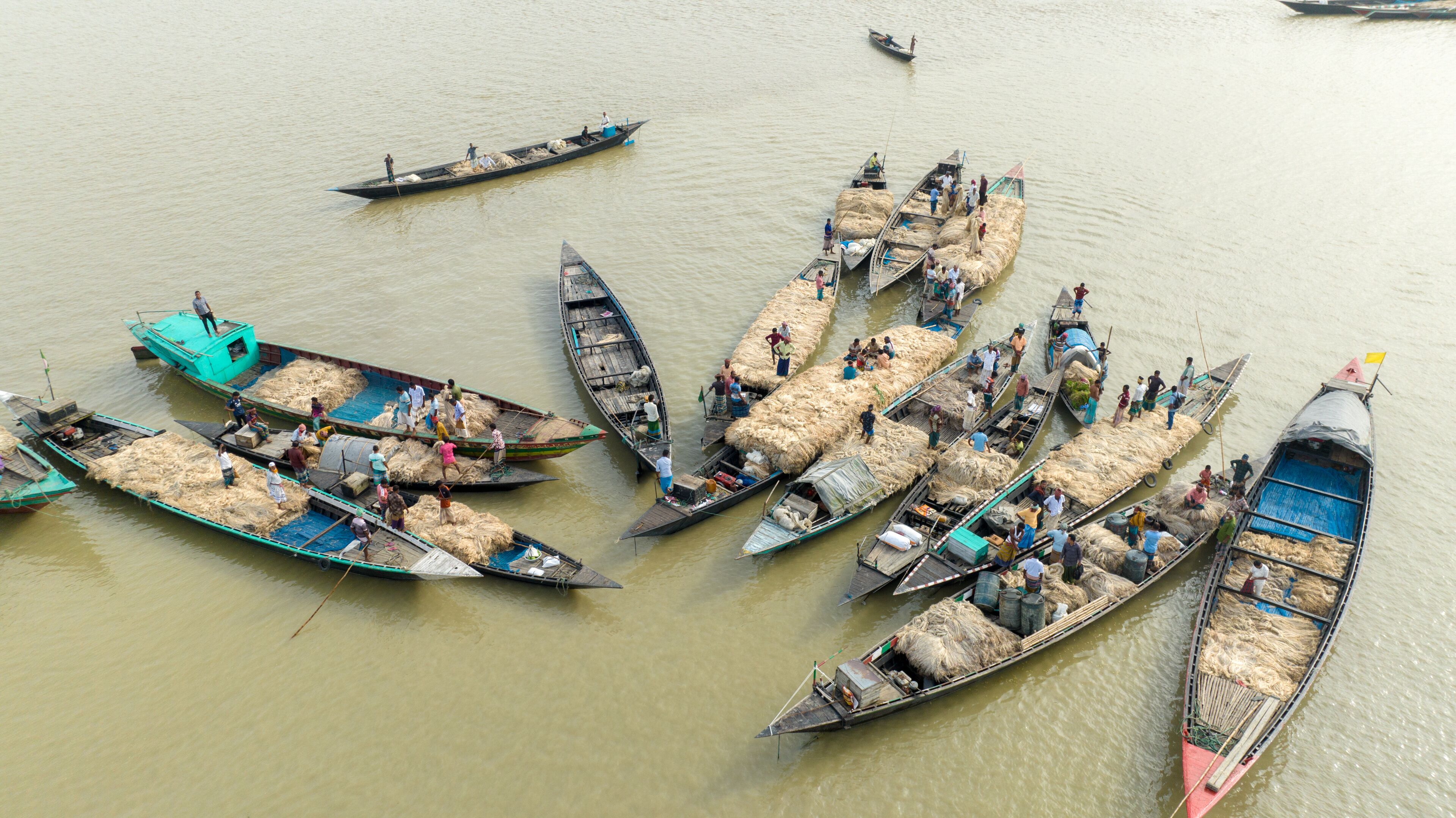Aerial view of many boats clustered together on the river, filled with goods and people, creating a busy scene of commerce, Kazipur, Rajshahi Division, Bangladesh.