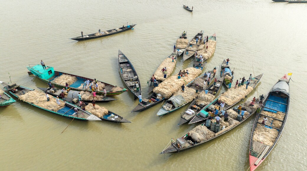 Aerial view of many boats clustered together on the river, filled with goods and people, creating a busy scene of commerce, Kazipur, Rajshahi Division, Bangladesh.