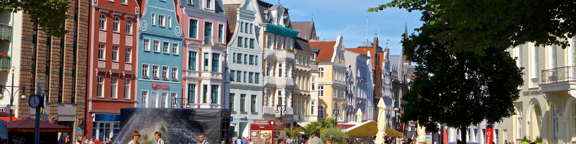 Rostock das einen Garten und Stadt sowie kleine Menschengruppe