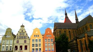 A row of colorful buildings with a church featuring a tall spire.