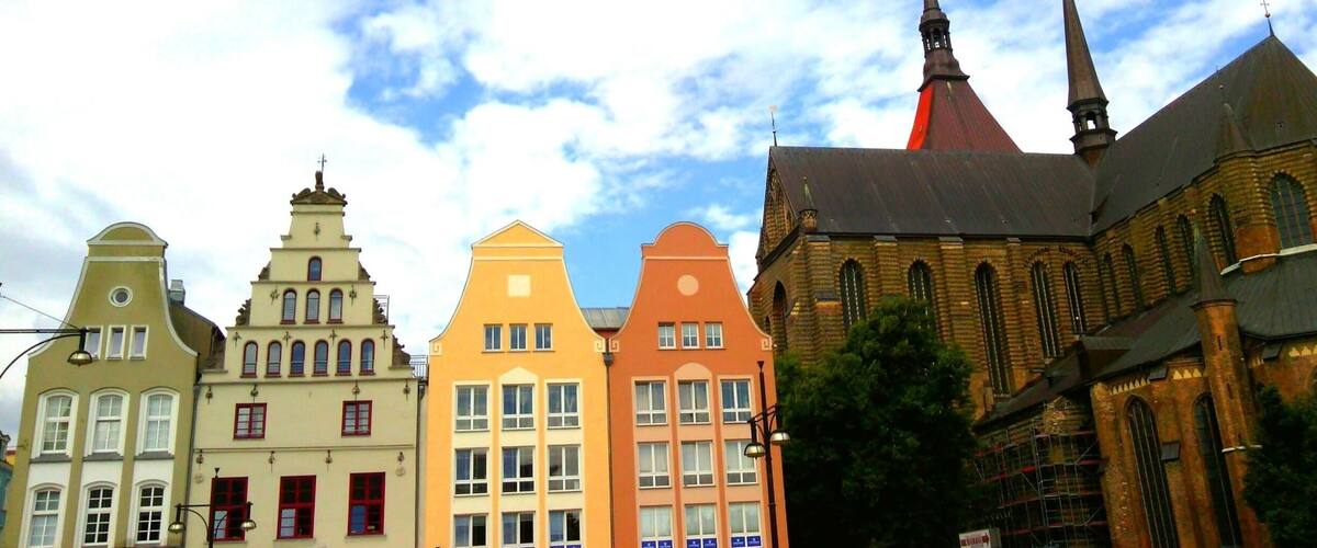 A row of colorful buildings with a church featuring a tall spire.