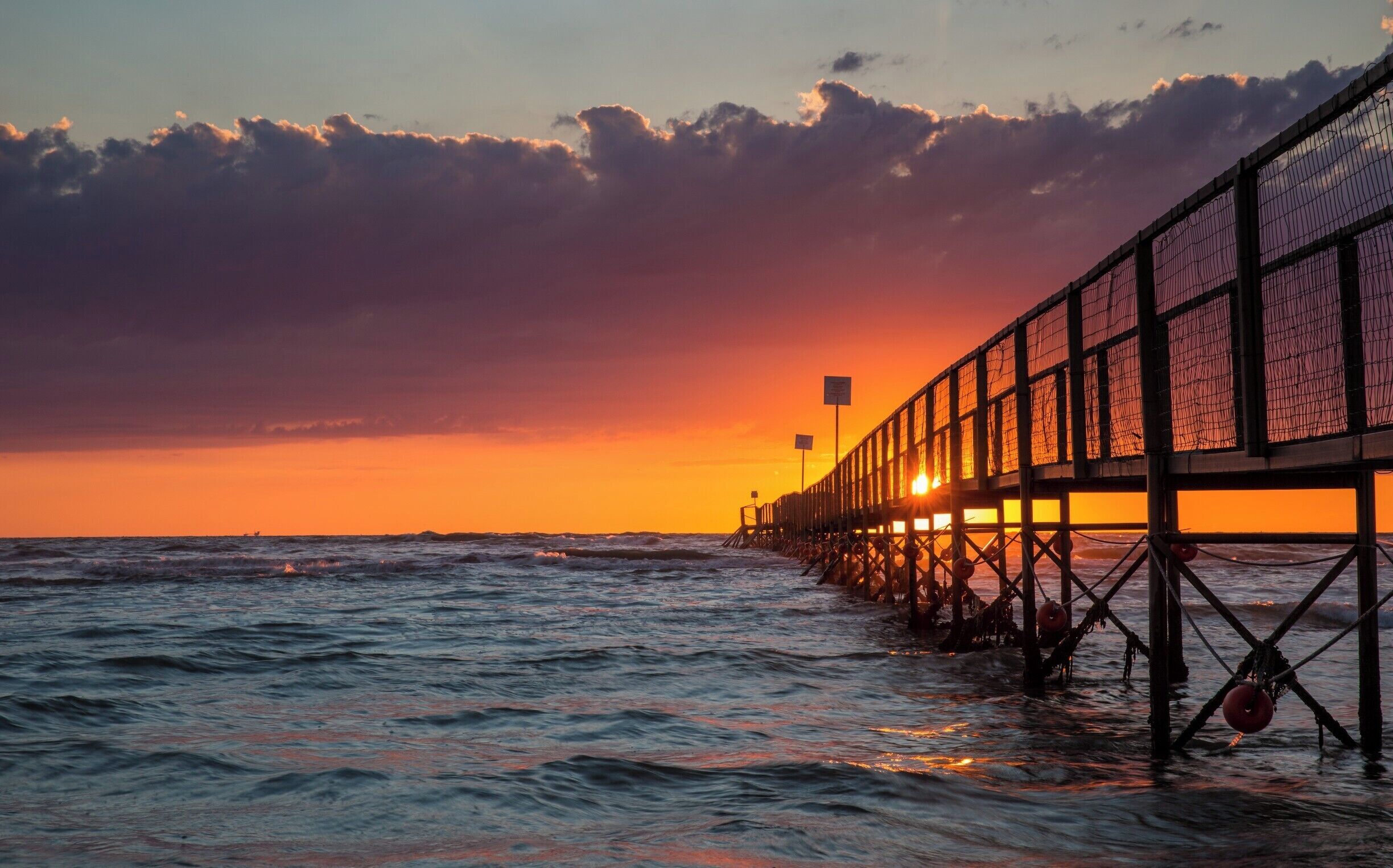 Jetty sunrise on the Adriatic coast in Rimini, Italy. 