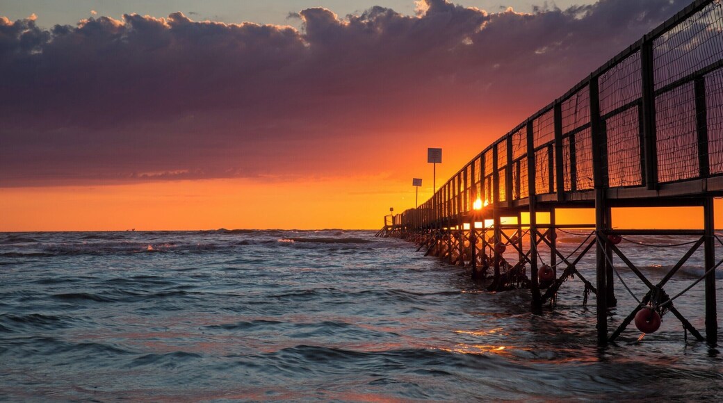 Jetty sunrise on the Adriatic coast in Rimini, Italy.
