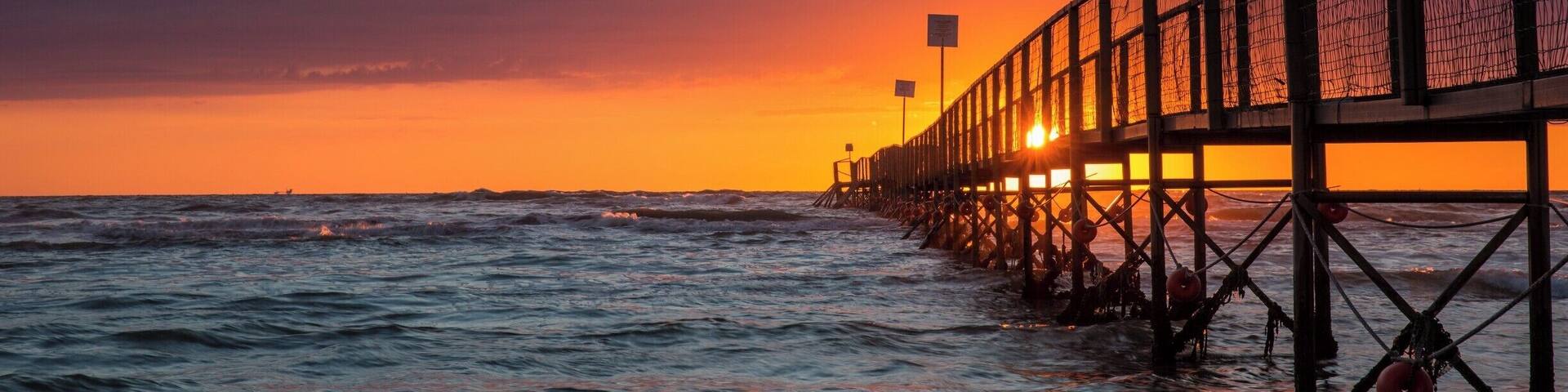 Jetty sunrise on the Adriatic coast in Rimini, Italy.