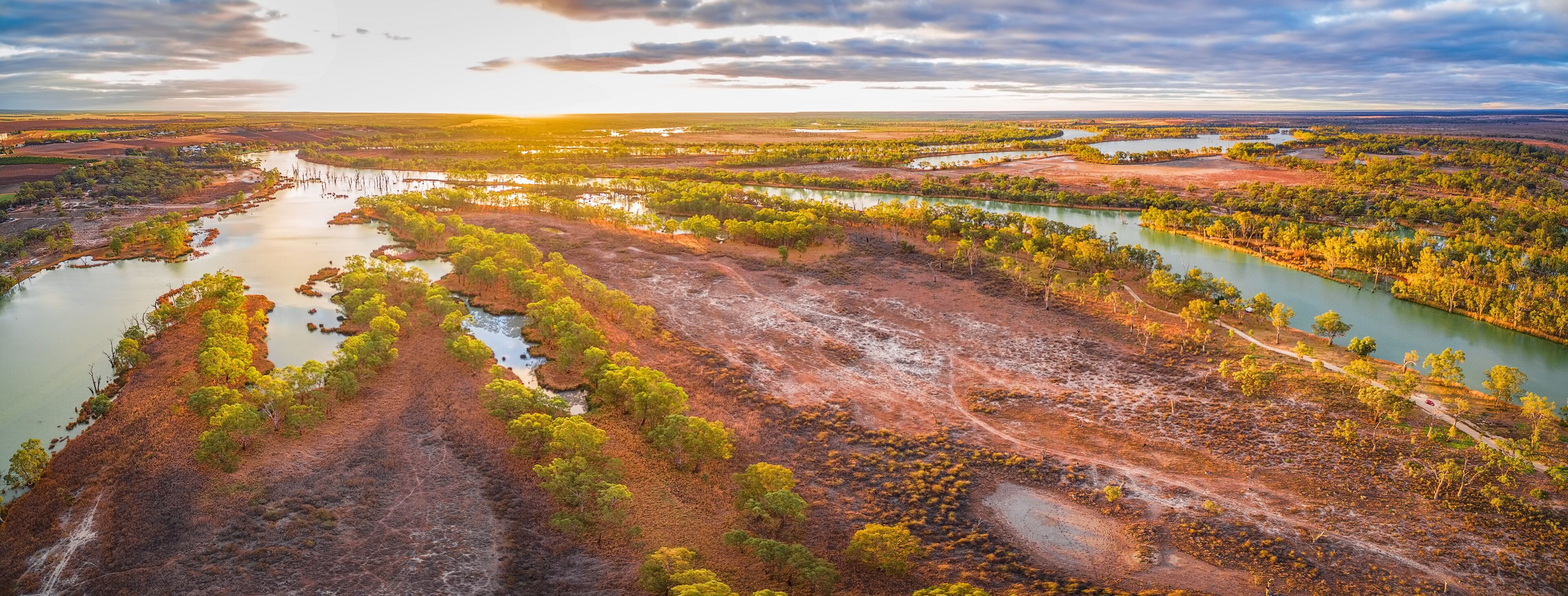 Wide aerial panorama of iconic Murray River flowing among native trees at sunset