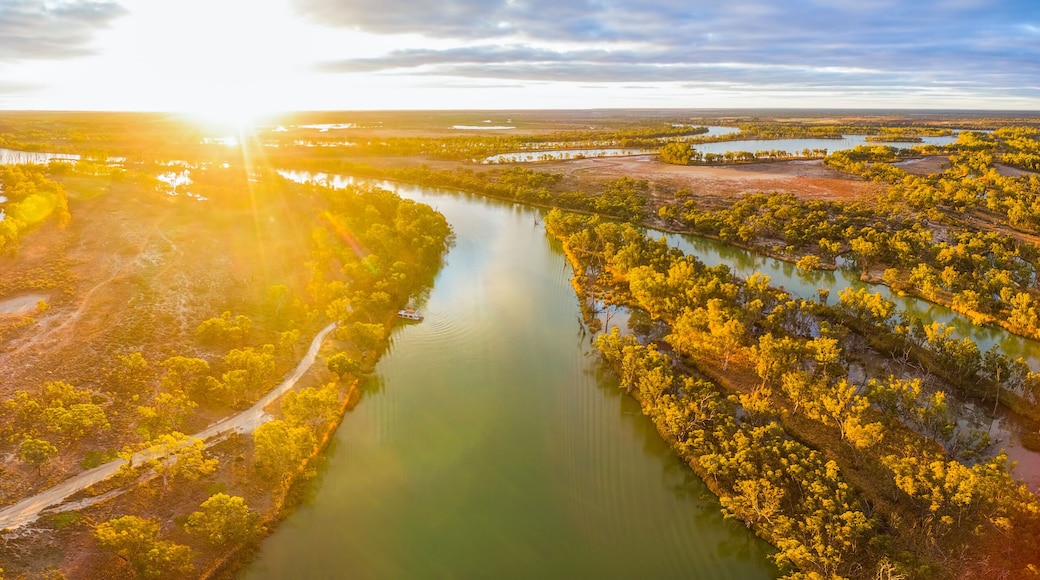 Aerial panorama of bright sun flare at sunset over Murray River in South Australia